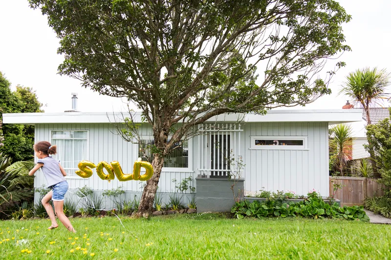Girl runs past bungalow with gold ‘SOLD’ balloons first home buyer