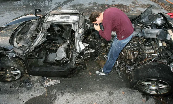 A journalist films the wreck of a black
