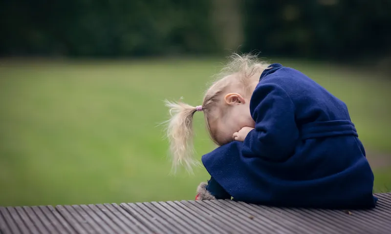 Little girl hiding her face in her hands