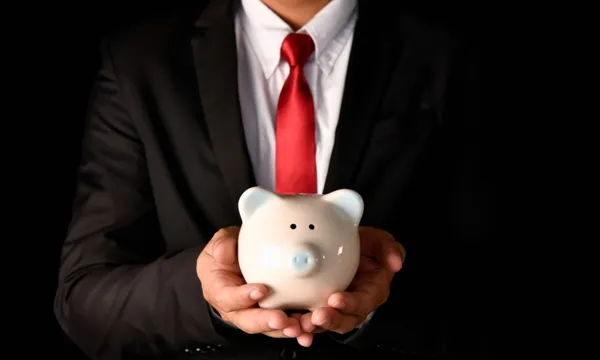 suit man holding piggybank getty images