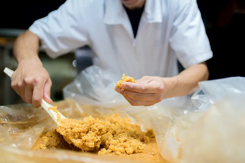 Japanese worker inspecting miso
