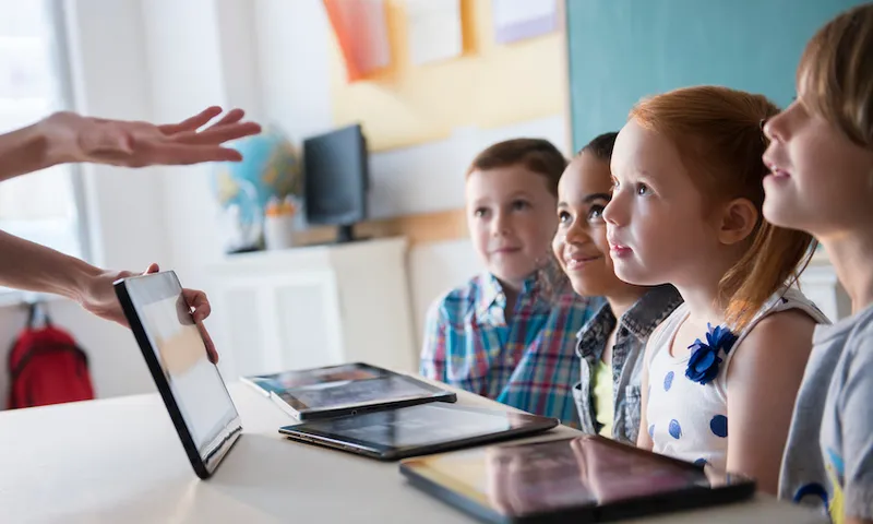 Teacher demonstrating digital tablet for students