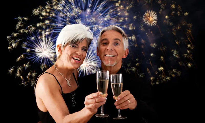 Portrait Of Smiling People Having Champagne Against Firework Display
