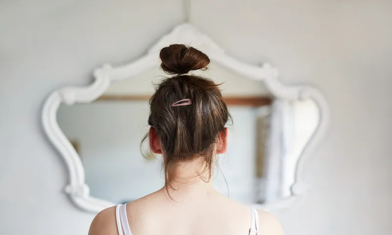 Young woman looking in the mirror