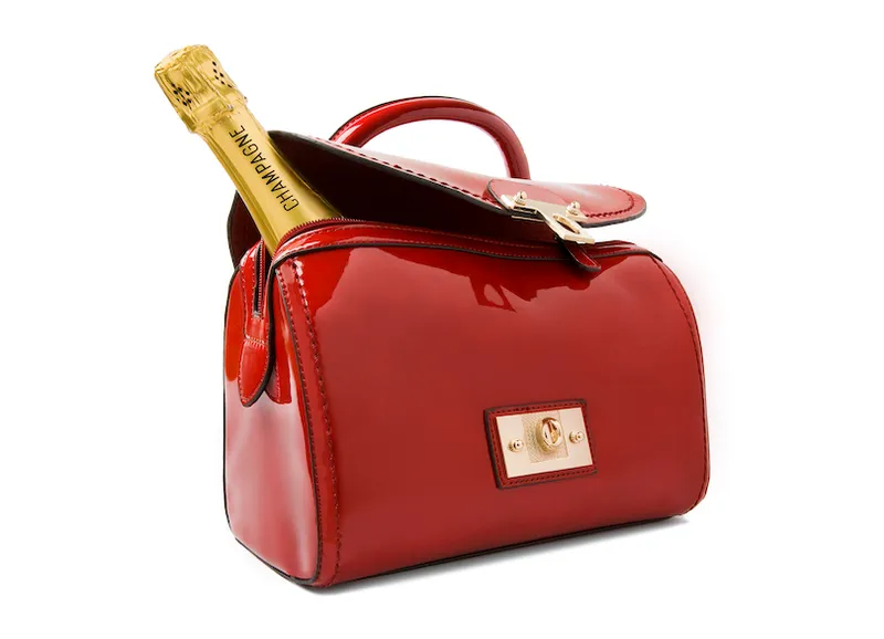 A bottle of Champagne in a red handbag.