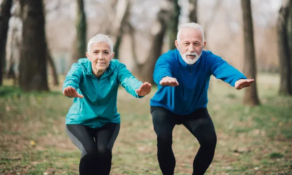 Elderly athletic couple exercising in the park