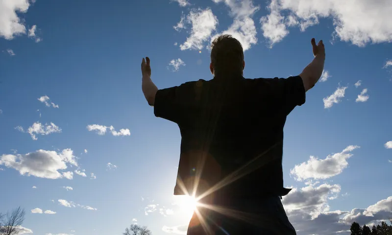 Man raising arms toward the sky
