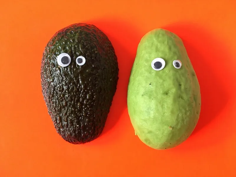 Close-Up Of Avocados Against Orange Background