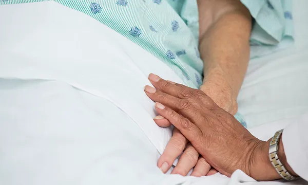 Doctor holding patient’s hand in hospital