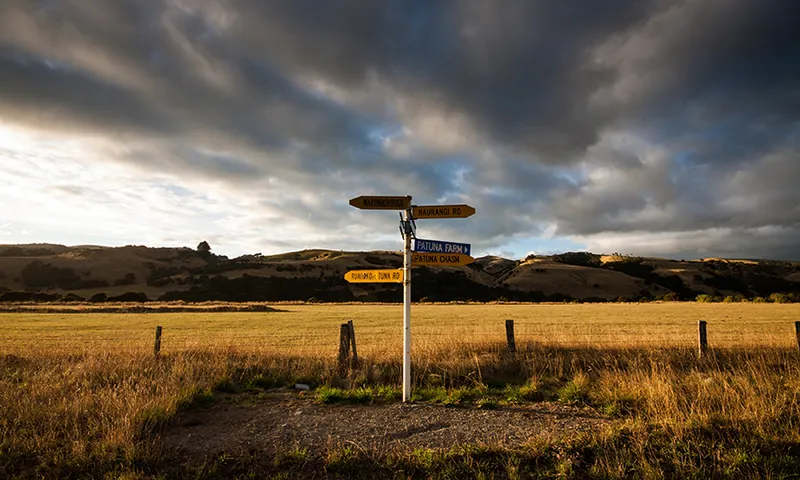 street sign in golden sunrise light with dramatic cloudy sky in background in rural Wairarapa