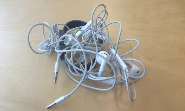 Close-Up Of Tangled Earphones On Table