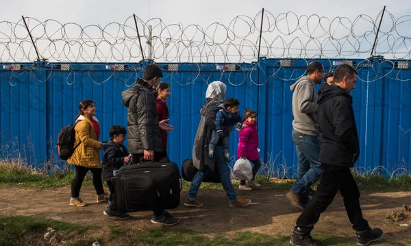 A family of Syrian refugees walking at the border between Serbia and Hungary Getty Images Omar Marques resized