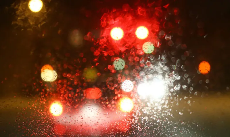 Dashboard view of a moving car on a rainy night