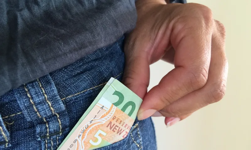 man taking money out of pocket getty