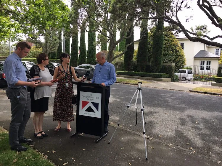 Reporters grill Morgan at the Opportunities Party policy launch event outside John Key's home.