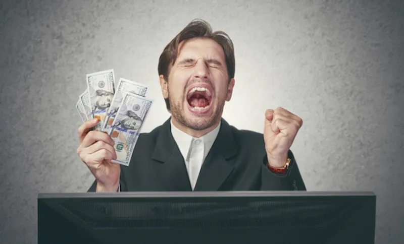 happy businessman with money in hand  and computer