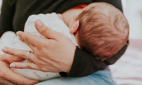 Midsection Of Woman Breastfeeding Baby