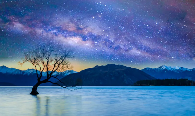 Scenic View Of Lake And Mountains Against Sky At Night