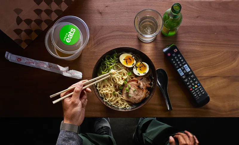 Man eating at home with chopsticks