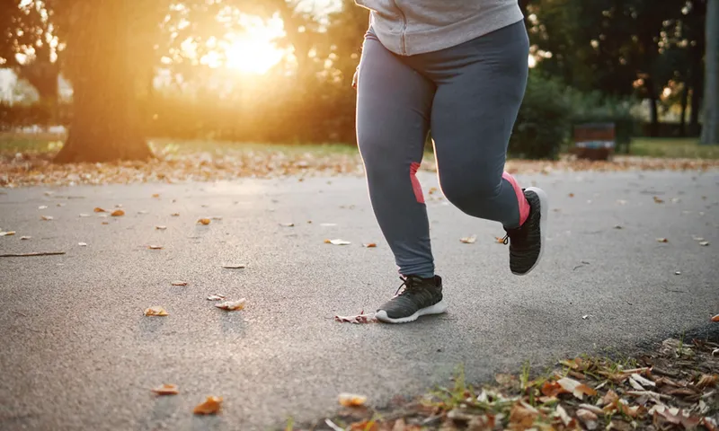 Curvaceous young female runner running in park, waist down