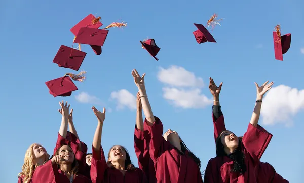 Line of Female Students Throwing Their Mortar Boards in the Air at Graduation