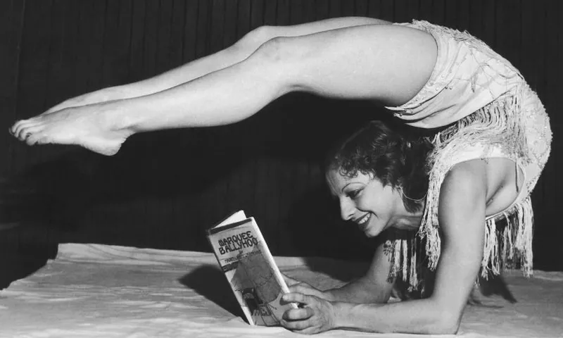 Dancer Gertrude Fisher laying with her legs bent over her head to read her husbands latest novel ‘Marquee Ballyhoo’, 1932. (Photo by FPG:Hulton Archive:Getty Images)