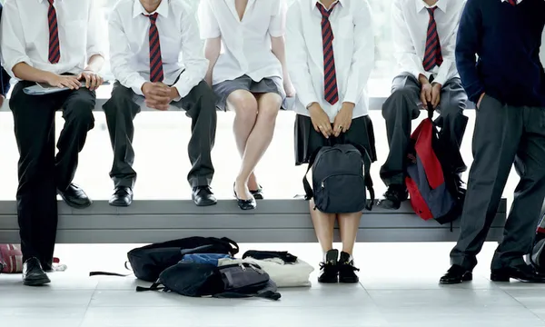 Six schoolchildren (14-16) relaxing by window