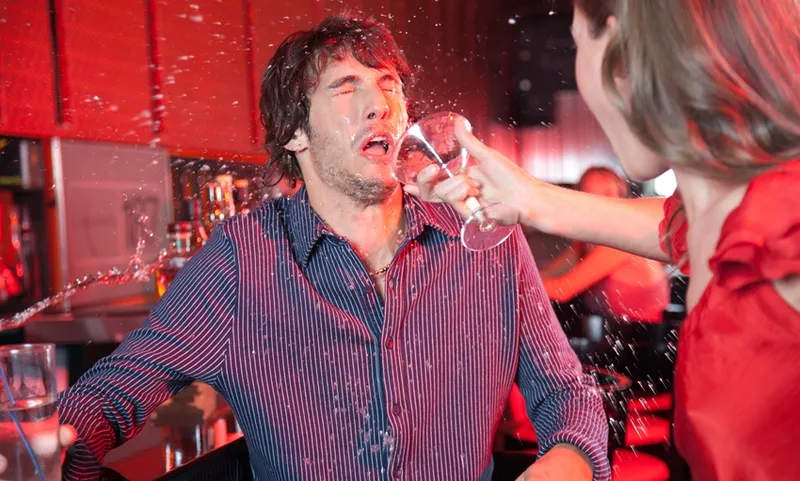 Woman in nightclub throwing beverage in man’s face