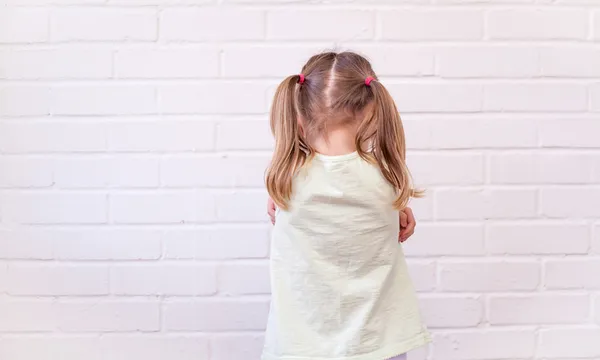 Girl Standing Against White Wall