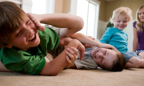 Boys play fighting on floor