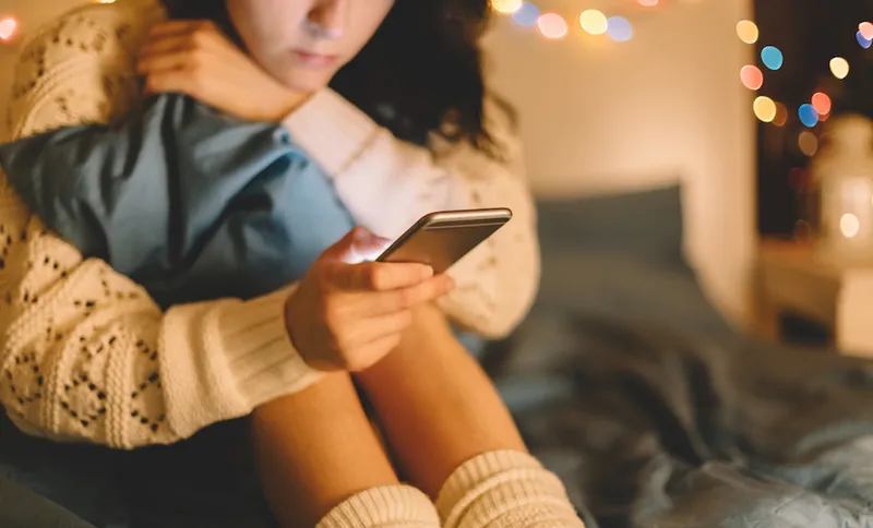 Girl on bed using a phone