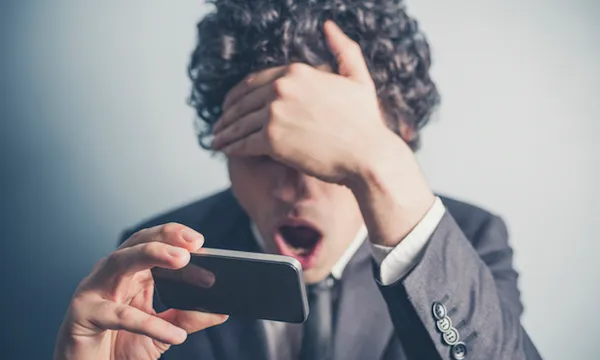 Shocked businessman reading on his smartphone