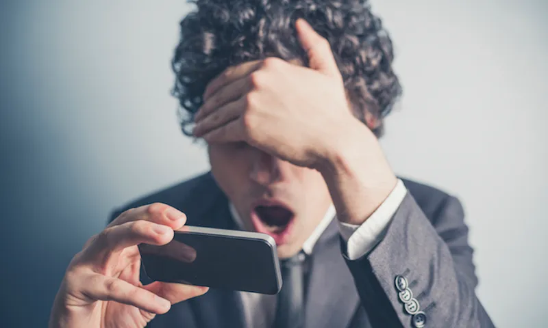 Shocked businessman reading on his smartphone