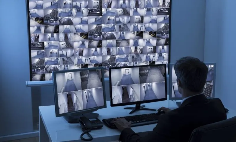 Man In Control Room Monitoring Cctv Footage