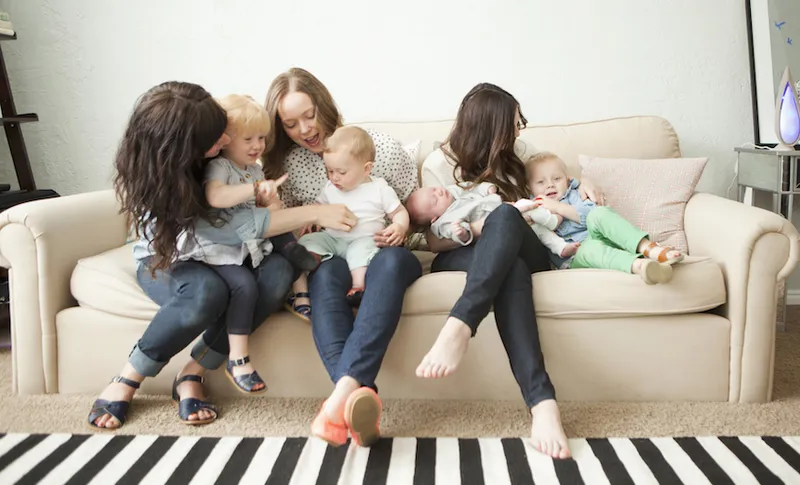 USA, Utah, Salt Lake City, Three young mothers with toddler girl (2-3) and two baby boys (2-5 months, 6-11 months) sitting together on sofa