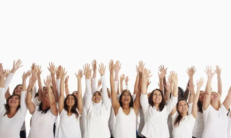 Crowd of diverse women celebrating with arms raised