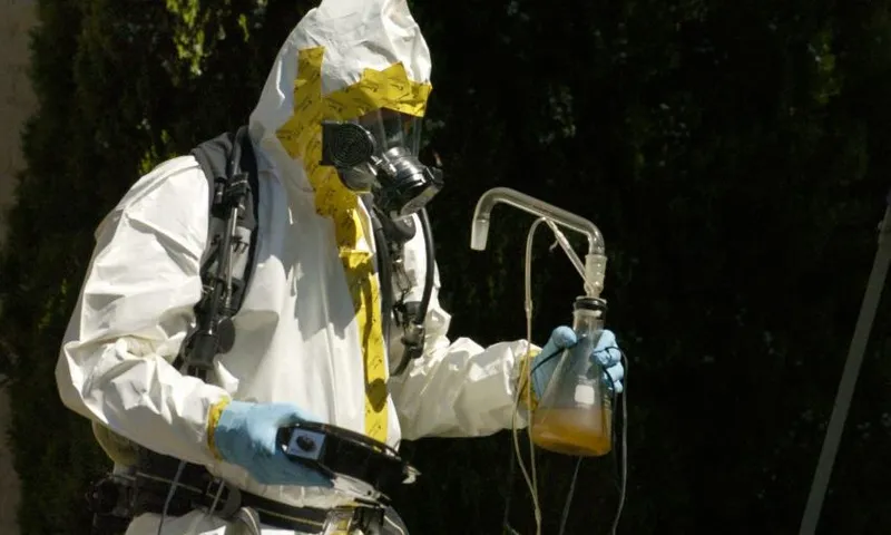 (LA)DENVER, COLORADO-JULY 18, 2007-A Denver Police Department vice narcotics officer, dressed in a haz-mat suit, carries meth lab equipment from a home in the 3100 block of Umatilla Street. The Denver Fire Department discovered a meth lab in the basement