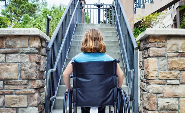 Disabled Girl in Wheelchair at the Bottom of Stairs