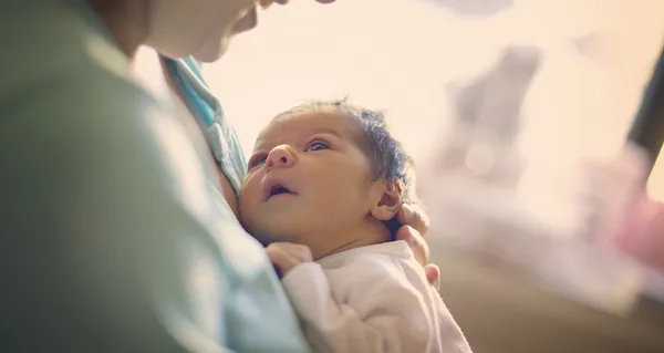 Mom smiling at newborn at hospital