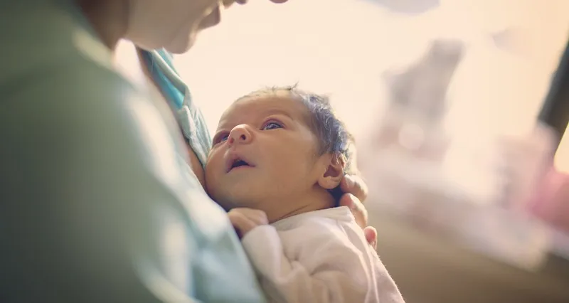 Mom smiling at newborn at hospital