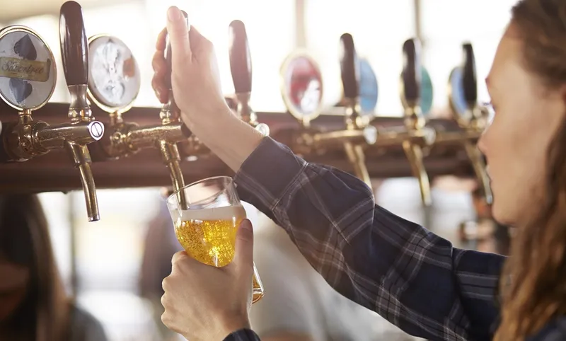 Bartender making cask beer at bar