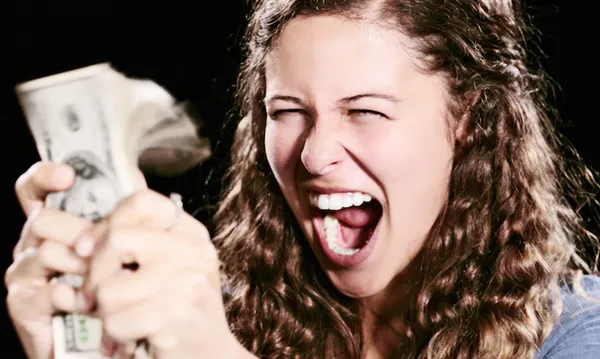 Delighted young woman with sheaf of dollars yells joyfully