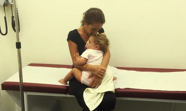 Mother holding child on a hospital bed