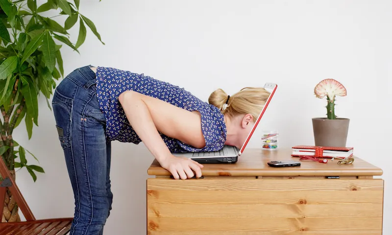 Young woman peering inside laptop screen