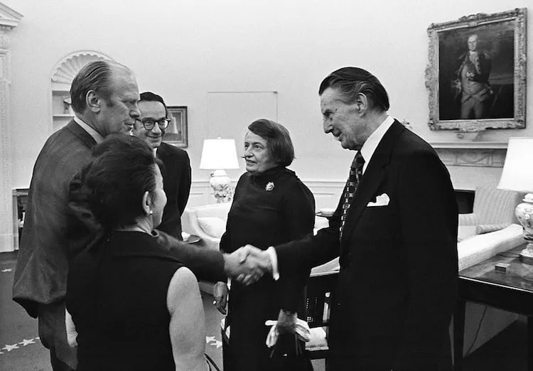 (L-R) President Gerald R. Ford, Alan Greenspan's mother Rose Goldsmith (back to camera), Alan Greenspan, writer Ayn Rand, and Rand's husband Charles Francis "Frank" O'Connor, after Greenspan's swearing in as Chairman of the Council of Economic Advisors in the Oval Office, September 4, 1974 (Photo by David Hume Kennerly/The Gerald R. Ford Library/Getty Images)