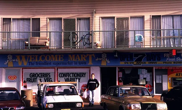 Man walking out of a suburban corner store