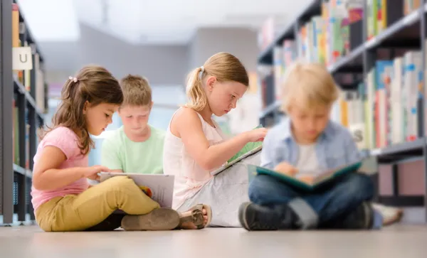 Group of children sitting on floor and reading