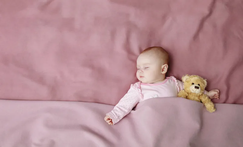 Baby girl sleeping in bed