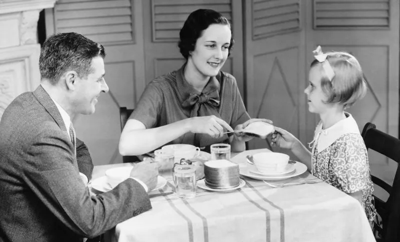 Parents with daughter (8-9) eating breakfast at home (B&W)
