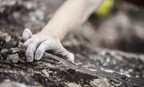 Hand of Caucasian man rock climbing